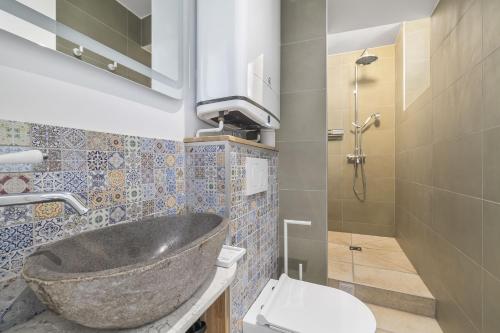 La salle de bains est pourvue d'un lavabo en pierre et de toilettes. dans l'établissement Chiquito, à Paris