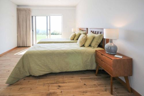 a bedroom with two beds and a table with a lamp at Casa Tranquilo in Refoios do Lima