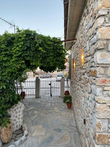 a stone wall with a gate and a stone walkway at Oneiropetra Luxury House in Argalasti