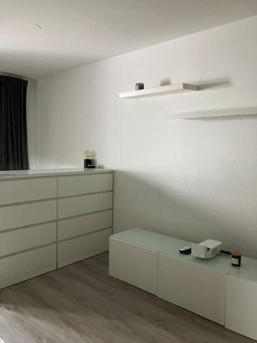 a white room with white cabinets and a table at Stilvolle Wohnung in Offenburg in Offenburg