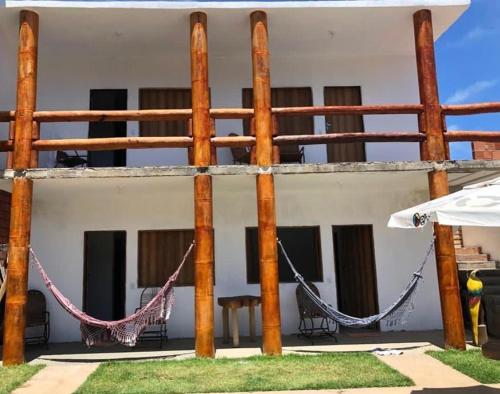 a porch with a hammock in front of a building at Pousada Cantinho de Milagres in São Miguel dos Milagres