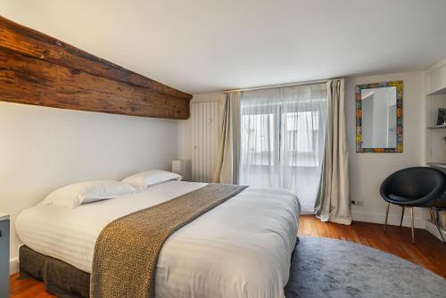 une chambre avec un grand lit et une fenêtre dans l'établissement Pavleo, à Paris