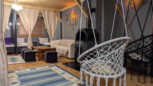 a living room with a white chair and a couch at Vila N&M in Visoko