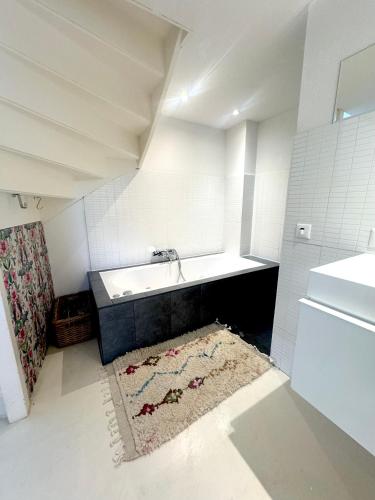 a bathroom with a sink and a bath tub at Houseboat PURE II in Vreeland