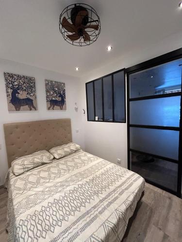 une chambre avec un lit et un lustre dans l'établissement Bandol-Plage EDEN ROC, à Bandol