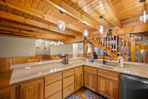 a large kitchen with wooden cabinets and a wooden ceiling at Round Top Way Cabin By Beyond Expectations in Sevierville