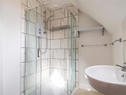 a bathroom with a glass shower and a sink at Campion Cottage in Watchet