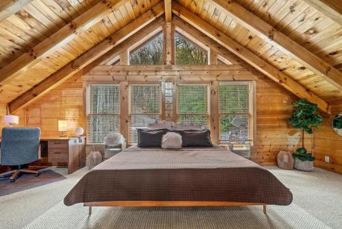 a bedroom with a large bed in a wooden house at Round Top Way Cabin By Beyond Expectations in Sevierville