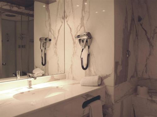 a bathroom with a sink and two phones on the wall at Cors'Hotel in Biguglia