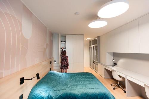 a woman standing in a bedroom with a large bed at Henry's Appt with a private Suite 413 - Shared kitchen in Luxembourg