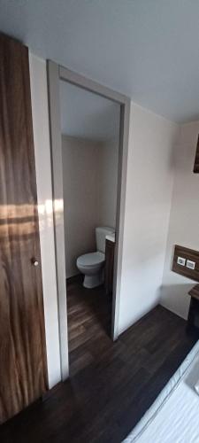 une salle de bains vide avec des toilettes et une porte dans l'établissement La Baume La Palmeraie Camping Resort, à Fréjus
