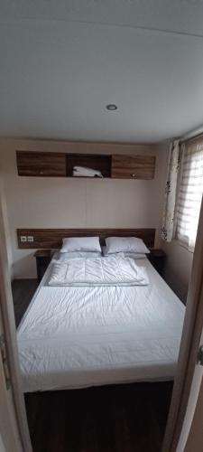 une chambre avec un grand lit avec des draps blancs dans l'établissement La Baume La Palmeraie Camping Resort, à Fréjus