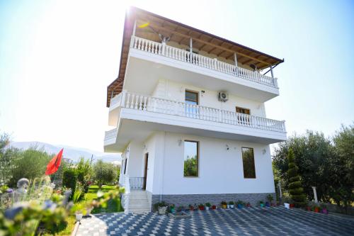 a white house with a balcony on top of it at Villa Visi in Moravë