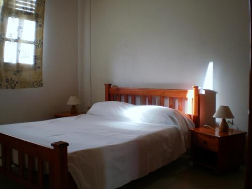 a bedroom with a bed with white sheets and a window at Abri Gens Libres in Le Marin