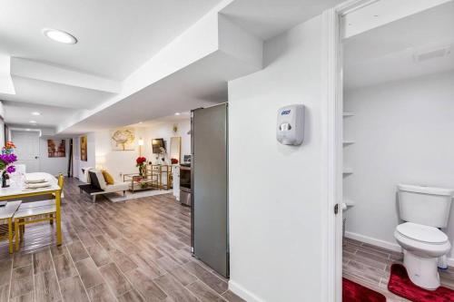 a bathroom with a toilet and a living room at Luxury Suite by Prudential Ctr & 7min to EWR Airpt in Newark