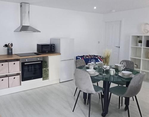 a kitchen and dining room with a table and chairs at Tollymore Lodge in Newcastle