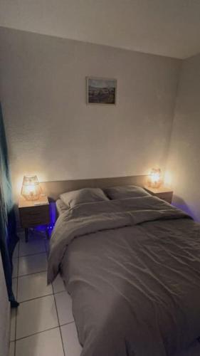 une chambre avec un lit avec deux lampes dessus dans l'établissement Charmant petit Appartement avec vue sur la mer, à Sète