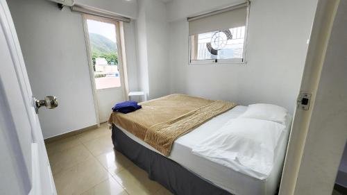 a small bedroom with a bed and a window at Acogedor apartamento en caracas in Caracas