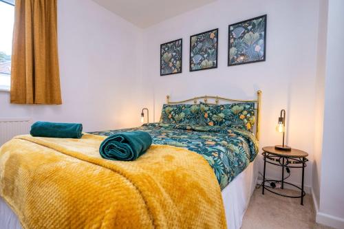 a bedroom with a bed with a yellow blanket at Splendid House Great Location to WAVE Surf & South West Water Park - Super Garden By StayStaycations in Bristol