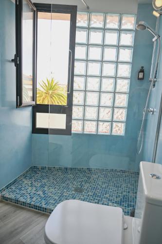 a bathroom with a shower and a toilet and a window at El Hierro Bed & Vintage in Valverde