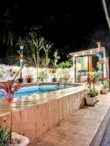 a swimming pool next to a wooden fence with plants at Family house プール付オーシャンビュー Amami "Birdland Nature Resort" in Amami