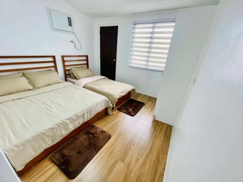 ein Schlafzimmer mit zwei Betten und einem Fenster in der Unterkunft Homestay CDO - Ventura in Cagayan de Oro