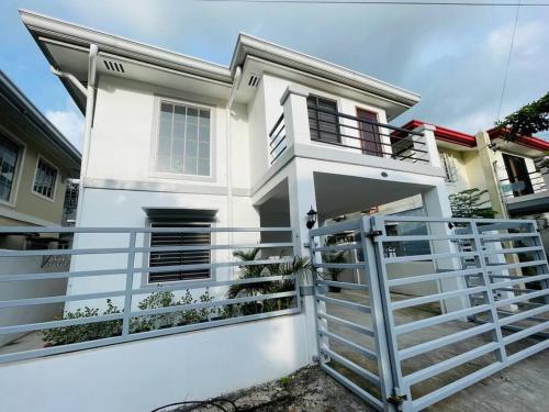 ein weißes Haus mit einem Zaun davor in der Unterkunft Homestay CDO - Ventura in Cagayan de Oro