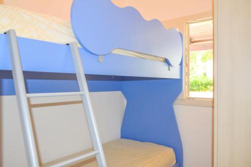 a bunk bed with a ladder in a room at Villetta Pinetata 452 in Ugento