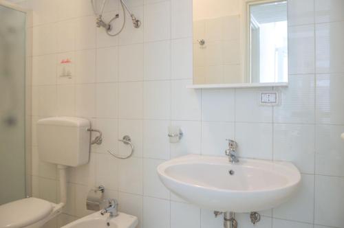 a white bathroom with a sink and a toilet at Villetta Pinetata 452 in Ugento