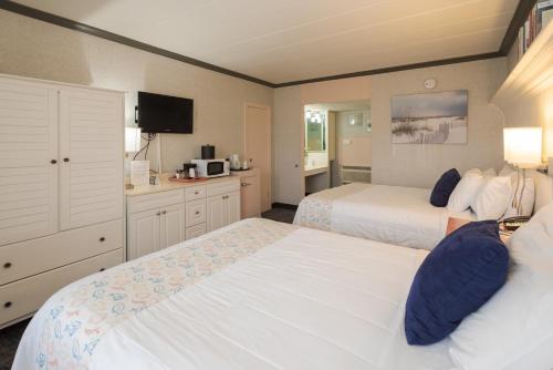 a hotel room with two beds and a kitchen at Gaido's Seaside Inn in Galveston