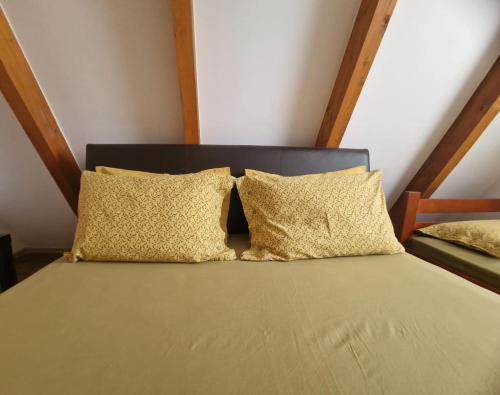 a bed with four pillows on it in a room at Green Eye in Žabljak