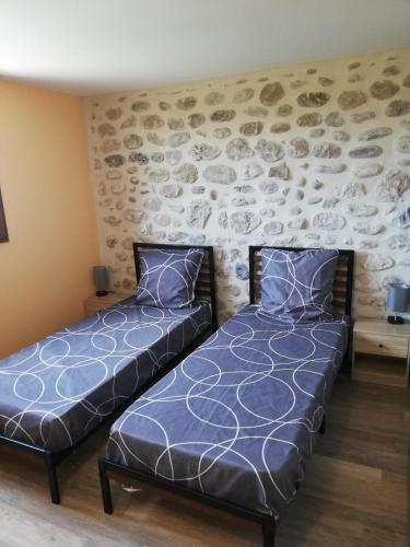 deux lits côte à côte dans une pièce dans l'établissement La Terrasse des vignes, à Saint-Sernin