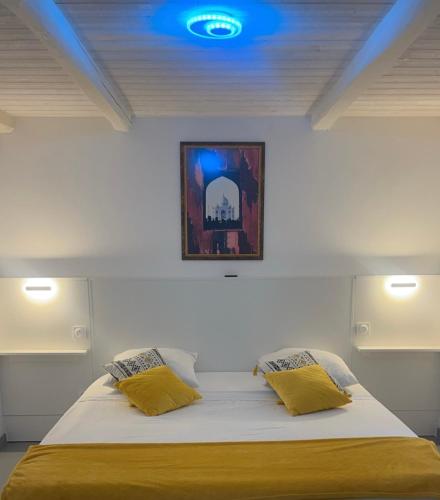 - une chambre avec un lit et 2 oreillers jaunes dans l'établissement Maison la Bouscasse, à Gabriac