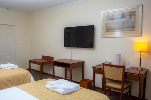a hotel room with two beds and a flat screen tv at Sol Victoria Hotel SPA & Casino in Victoria