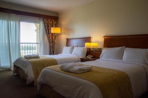 a hotel room with two beds and a window at Sol Victoria Hotel SPA & Casino in Victoria
