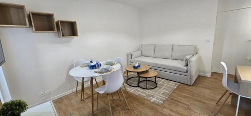 un salon blanc avec un canapé et une table dans l'établissement Studio d'architecte en plein cœur de Paris 7ème arrondissement, à Paris