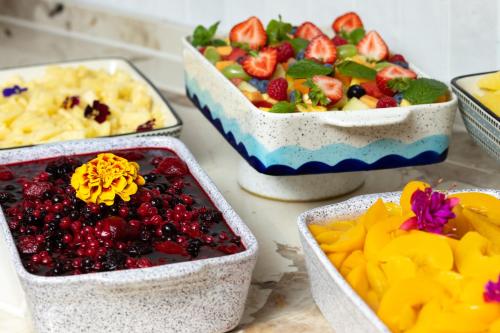 four bowls of fruit and other food on a table at Mercure London Earls Court in London