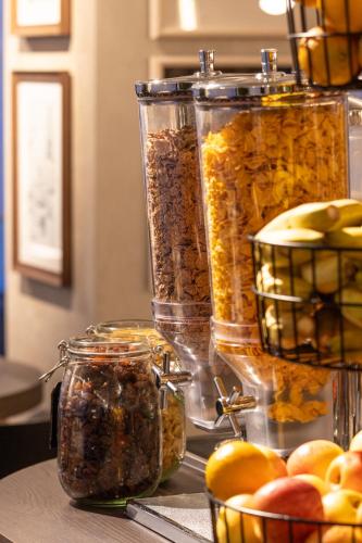 a group of jars of food on a counter with fruit at Mercure London Earls Court in London