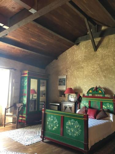 - une chambre avec un lit vert dans l'établissement Maison historique en Perigord, à Belvès
