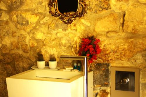 a white refrigerator in a room with a stone wall at Il Carosello dei Baroni in Noto