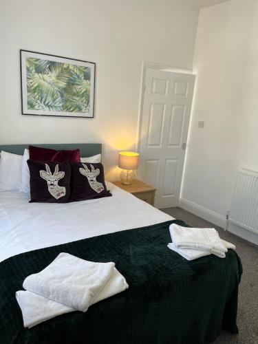 a bedroom with a bed with two towels on it at Lister House in Hartlepool