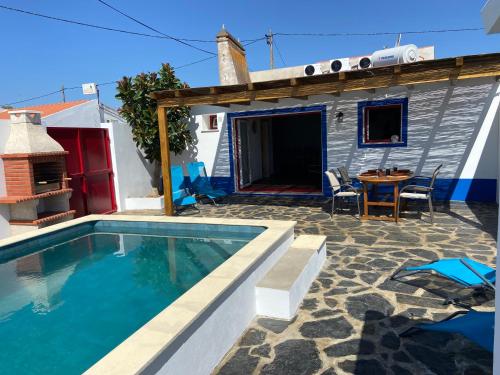 a backyard with a swimming pool and a house at Casa da Oriola in Oriola