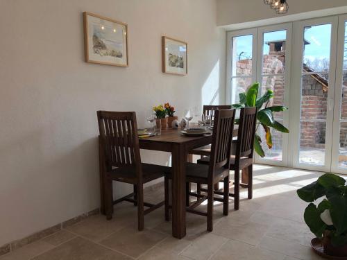 a dining room with a wooden table and chairs at Ferienwohnung Welschenkramer in Übersee