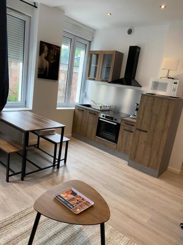 un salon avec une table et une cuisine dans l'établissement Marcq cocon, à Marcq-en-Barœul
