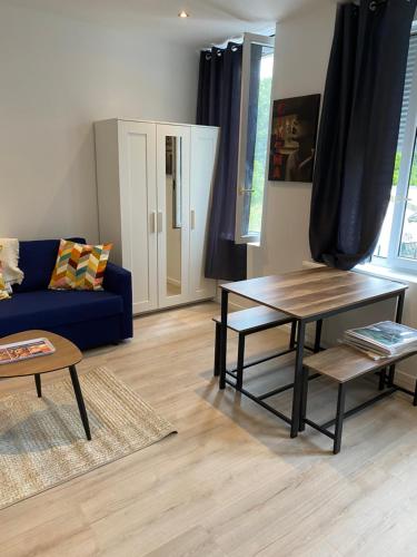 un salon avec un canapé bleu et une table dans l'établissement Marcq cocon, à Marcq-en-Barœul