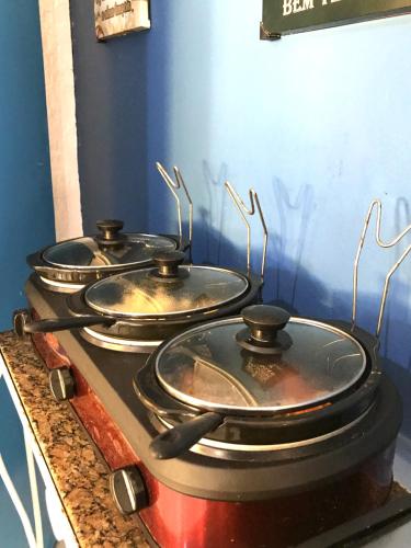 a group of four pots sitting on top of a stove at Pousada Turquesa By Gente Bonita in Búzios