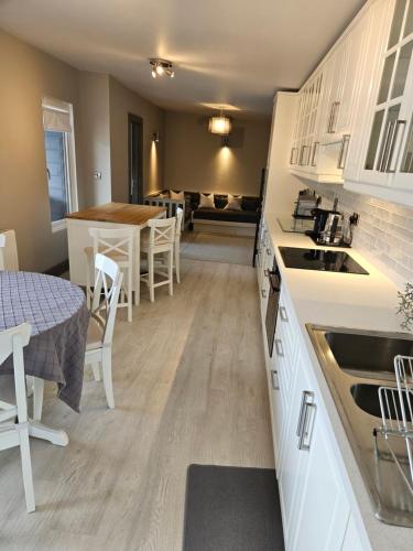 a kitchen with white cabinets and a table and a table and chairs at Casa Griffin in Tralee