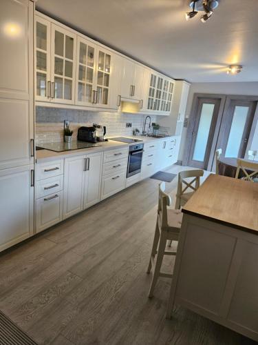 a large kitchen with white cabinets and a table at Casa Griffin in Tralee