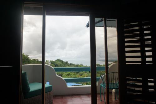 a room with a view of the ocean from a balcony at Hotel Planeta Sano in Manuel Antonio