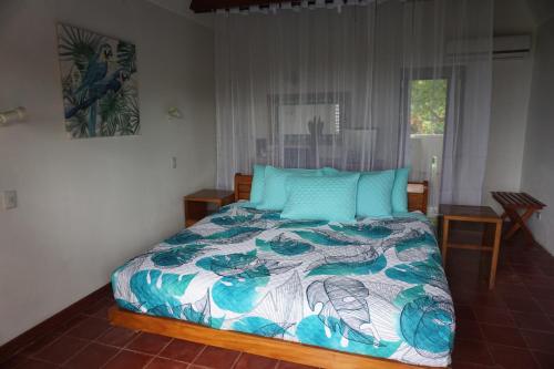 a bedroom with a bed with a colorful bedspread at Hotel Planeta Sano in Manuel Antonio